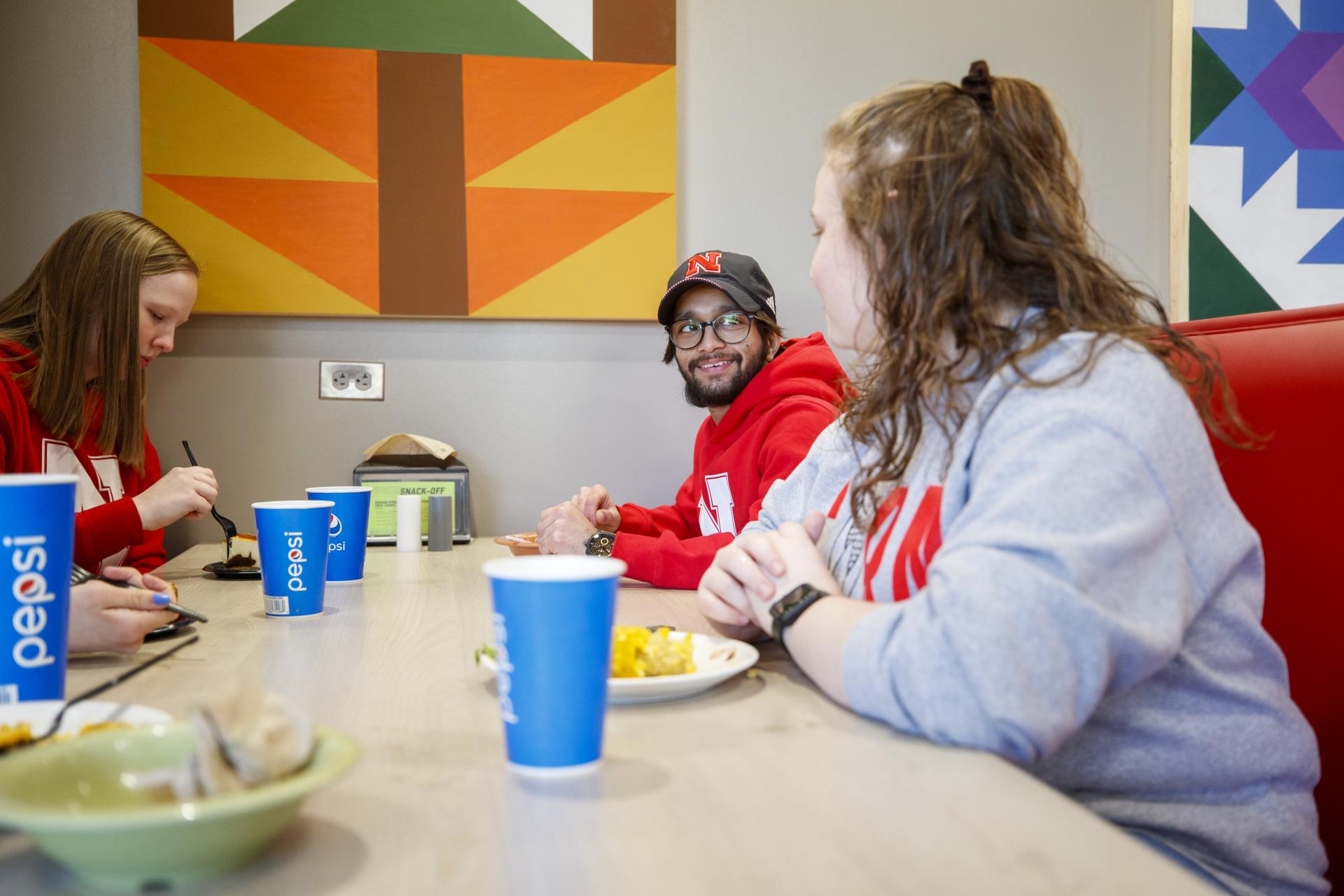 Students dine in a booth at the East Campus Dining Center