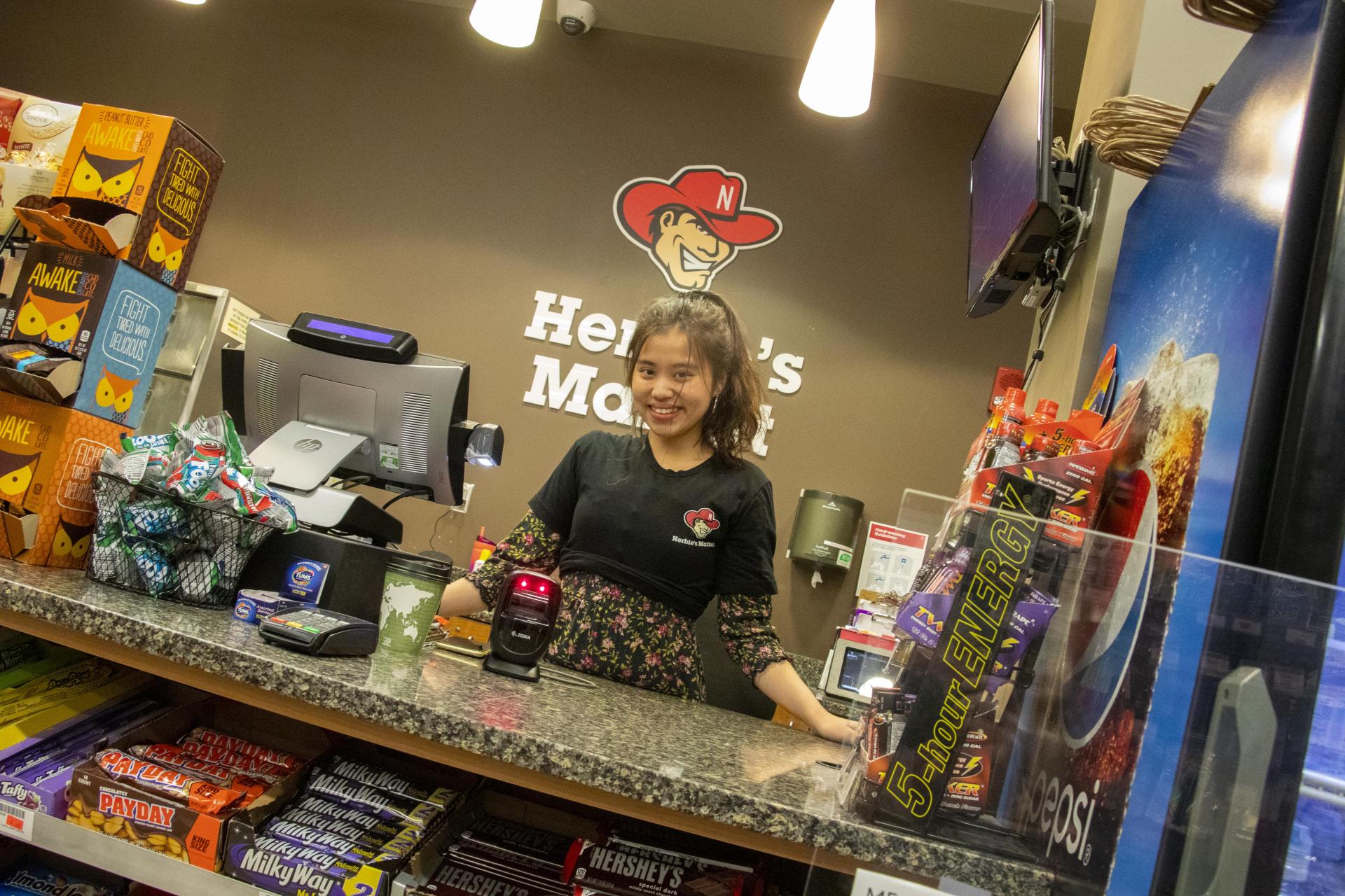 Dining student employee Linh Tran behind the counter at Herbie's Market at Abel