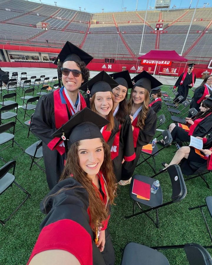 Students pose for a selfie during graduation in Memorial Stadium