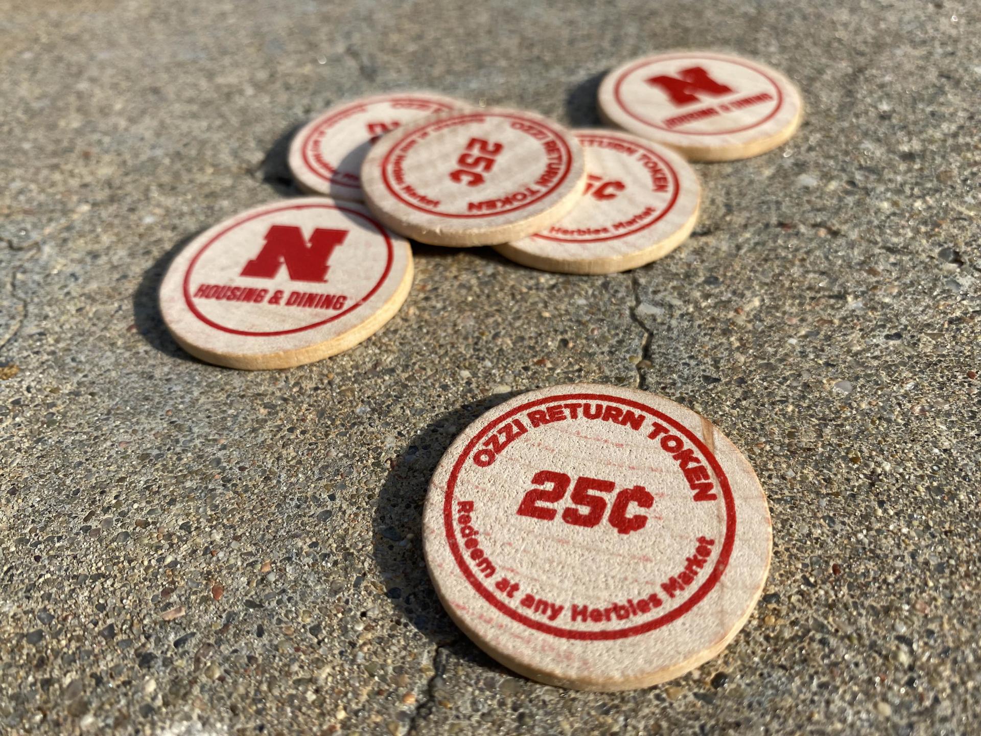 Wooden OZZI tokens lay on the cement