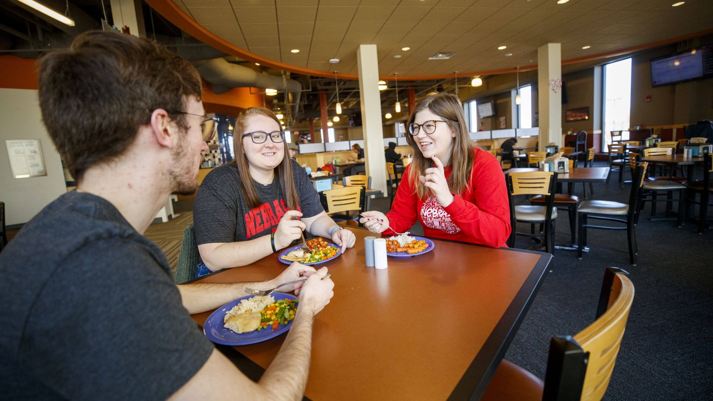 Students smiling as they enjoy a meal in Harper Dining Center.