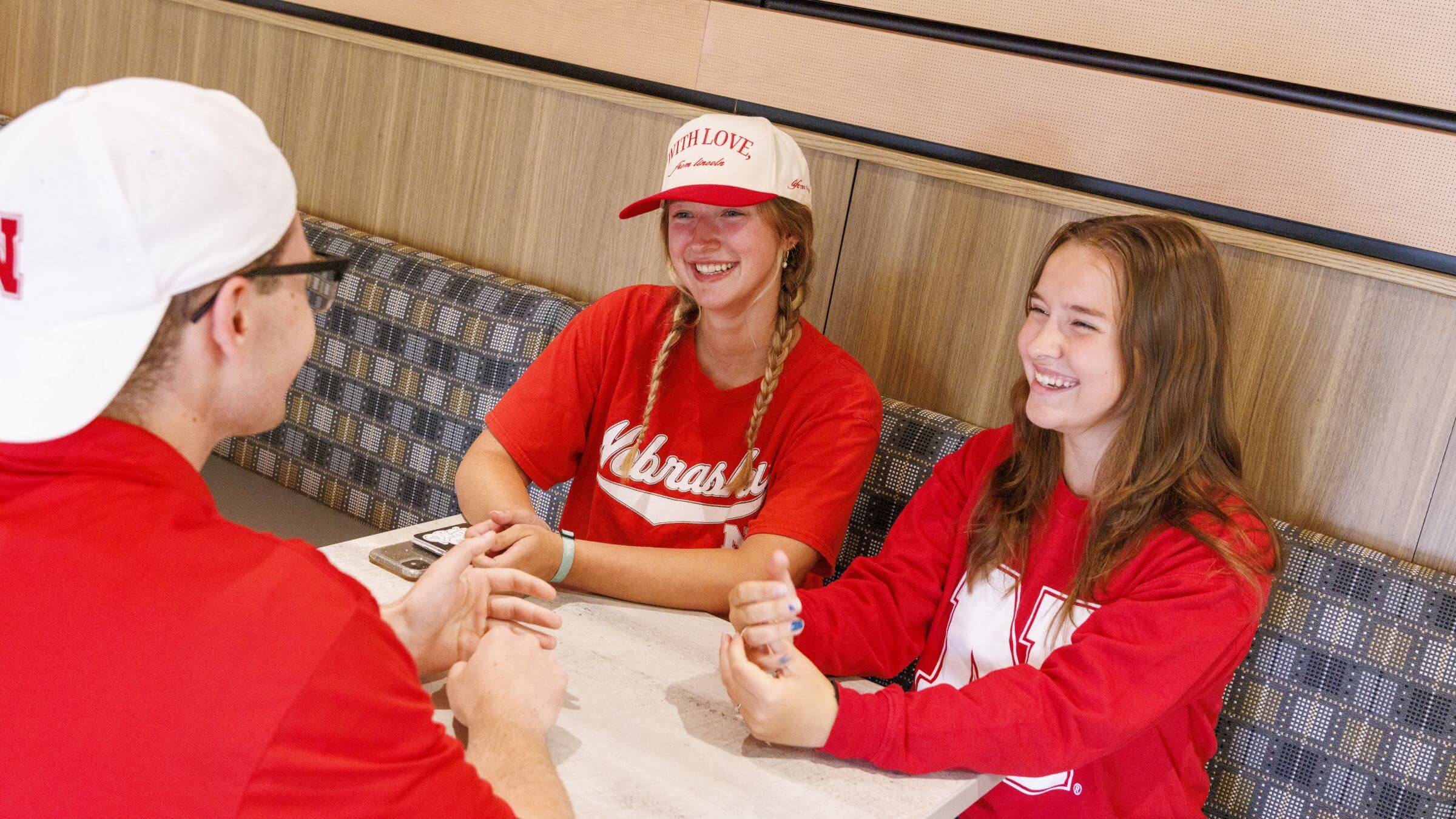 Students smiling while dining in Moxie's Cafe, within Selleck Dining Center.