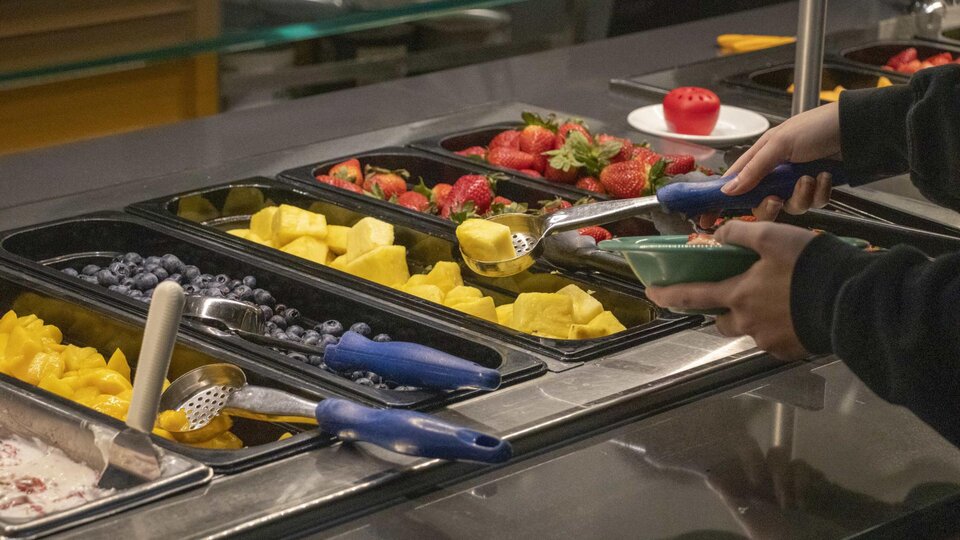 Customer selects fruit from an all you care to eat selection
