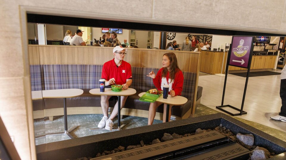 Two students dine in Selleck Dining Center using reusable OZZI containers.