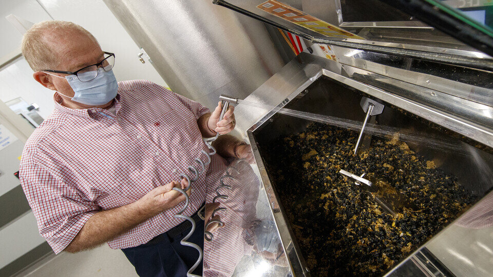 Dave Annis, director of dining services, rinses out a biodigester