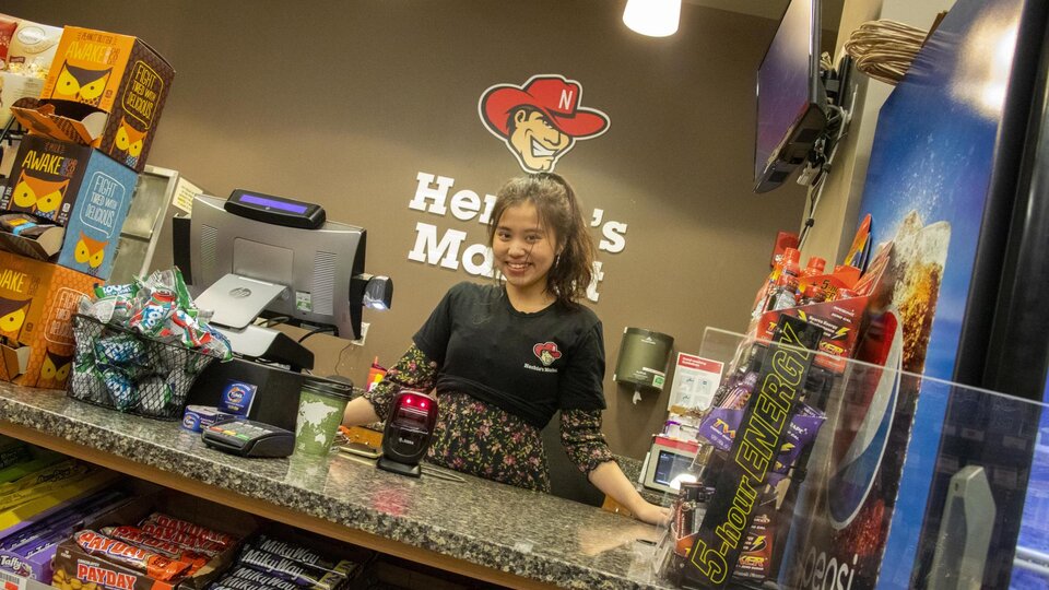 Dining student employee Linh Tran behind the counter at Herbie's Market at Abel