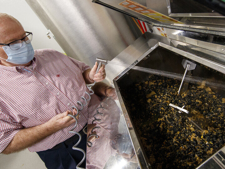 Dave Annis, director of dining services, rinses out a biodigester